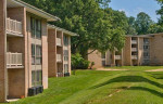 Exterior view of Aspen Hill Apartments in Silver Spring MD, featuring modern architecture and green space.