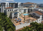 Aerial view of a modern apartment complex with a heated pool and fitness center in Coral Gables, FL.