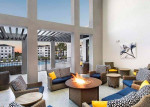 Modern lounge area featuring a fire pit, stylish seating, and views of the swimming pool in a Cape Coral apartment community.
