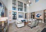 Modern apartment lobby with high ceilings, contemporary furniture, and large windows, ideal for community living.