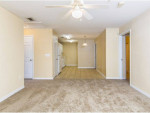 Spacious living area in a 5 bedroom apartment in Kissimmee with kitchen and carpeted flooring