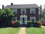 Exterior view of a red brick colonial building with a private entrance, located near Clarendon Metro in Arlington.