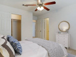 Cozy bedroom featuring a ceiling fan, spacious layout, and closet space in a renovated apartment.