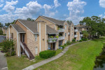 Exterior view of The Park at Via Veneto apartments in Jacksonville, FL, showcasing greenery and modern design.