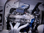 Close-up of a high-performance engine in a 1932 Ford Roadster, showcasing details of the carb and exhaust.