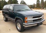 1996 Chevrolet Tahoe LT in dark green color, parked with clean exterior and chrome accents, showcasing its classic SUV design.