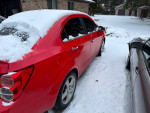 2015 Chevrolet Sonic LTZ in red parked in snow, featuring Weather Tech mats and fog lights.