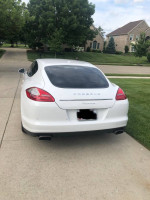 Rear view of a white 2011 Porsche Panamera parked on a driveway, showcasing its elegant design.