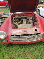 1962 MG Midget convertible, engine view for restoration or parts, parked on grass.