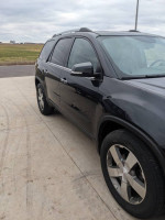 Side view of a 2012 GMC Acadia SLT AWD, black exterior, rust-free with a new remanufactured motor.