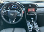 Interior view of Honda Civic featuring steering wheel, dashboard with infotainment system, and gear shift.