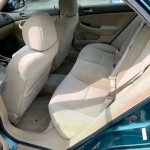 Interior view of Honda Accord backseat with beige upholstery and spacious seating area.