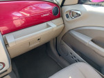 Interior view of a 2006 Chrysler PT Cruiser Touring Wagon showing red dashboard and beige seating.