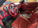 Interior view of a 2008 Porsche Boxster RS 60 Spyder with red leather seats and dashboard.