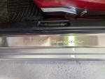 Close-up of the RS 60 Spyder door sill in a 2008 Porsche Boxster with red leather interior.