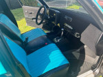 Interior view of a 1978 Chevrolet Malibu Custom Wagon with teal and black seats and modern features.