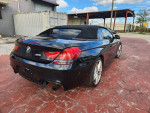Black 2014 BMW 6 Series 640i convertible parked with light damage, showcasing sleek design and alloy wheels.