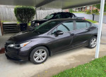 2014 Chevrolet Cruze 1LT parked under a shelter, in good condition with no scratches.