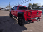 2019 Chevrolet Silverado 1500 Rocky Ridge, lifted with aggressive off-road tires, showcasing its striking red exterior.