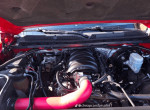 Close-up view of a Chevrolet Silverado 1500 engine with red intake tubing and engine components