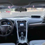 Interior view of a 2015 Ford Fusion showing dashboard, steering wheel, and infotainment screen.