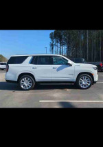 2021 Chevrolet Tahoe High Country SUV in white, parked outdoors, features spacious interior and all-wheel drive.