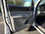 Interior view of the driver's door in a mid-size 2020 Toyota Tacoma SR pickup truck