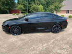 Side view of a black 2016 Chrysler 200S with heated leather seating and panoramic roof in a parking area.