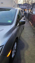2018 Honda Odyssey LX in silver, parked outside, showcasing rear-view mirror and side profile.