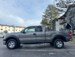 2007 Ford F-150 XLT 4WD pickup truck parked on a paved surface with residential buildings in the background
