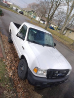 2010 Ford Ranger pickup truck in white parked on the street, featuring low mileage and a clean interior.