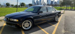 2001 BMW 7 Series 740iL in black, parked with skyline view, showcasing its clean condition and well-maintained features.