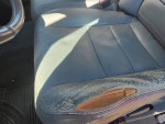 Close-up of worn leather seat in 2003 Ford F350 diesel truck interior
