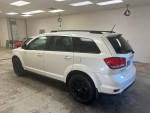 2014 Dodge Journey R/T in white with black wheels parked indoors, showcasing its sleek design and spacious SUV features.