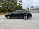 Side view of a black 2010 Lincoln MKT with 62,000 miles parked on a residential street.