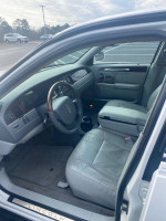 Interior view of a 2006 Lincoln Town Car with leather seats and a wooden steering wheel.