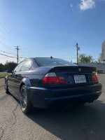 2004 BMW M3 in Mystic Blue with gray interior, 142k miles, needing cosmetic TLC, parked outdoors.