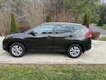 2014 Honda CR-V EX-L FWD parked on driveway, showcasing its sleek design and well-maintained appearance