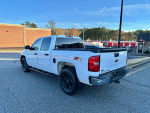 2010 Chevrolet Silverado 1500 LT 4WD, white crew cab with running boards parked on the street.