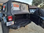 Rear view of 2012 Jeep Wrangler Sahara 4WD for sale, featuring soft top and for sale sign.