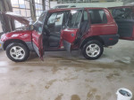 Low mileage red RAV4 with clean title for sale, parked with doors open in a garage.