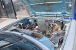 Overview of the engine bay of a 1978 Honda Civic, featuring weathered components and surface rust.