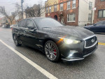 2018 INFINITI Q50 Red AWD parked on the street, showcasing its sleek design and clean condition