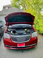 Under the hood of a 2014 Chrysler Town & Country showing engine details in Deep Cherry Red.