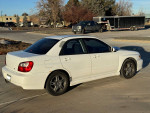 2002 Subaru Impreza WRX in white, parked, featuring manual transmission and 119,000 miles, showing sporty design.