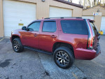 2007 Chevrolet Tahoe LTZ with new parts, parked outside a garage, showcasing its sleek design.