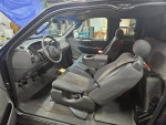 Interior view of a 2002 Ford F-150 showing front seats and dashboard features.