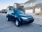 2010 Subaru Forester in excellent condition, parked in front of houses, showcasing its all-wheel drive feature.