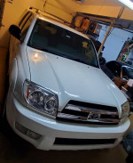 2005 Toyota 4Runner SR5 4WD in white color parked in garage, featuring V8 engine and tow package.