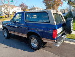 Rare 1996 Ford Bronco Eddie Bauer in midnight blue, featuring 4WD and 133,000 miles, parked on a street.